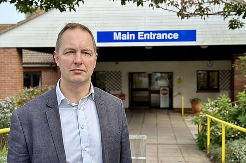 Richard Foord standing in front of the entrance to Seaton Hospital