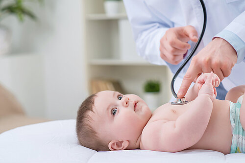 A baby being checked using a stethoscope.