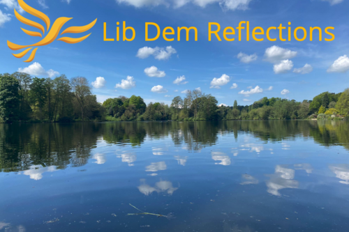 Lib Dem Reflections, Tree lined lake reflected in the water - Photo Chloe Clutterham