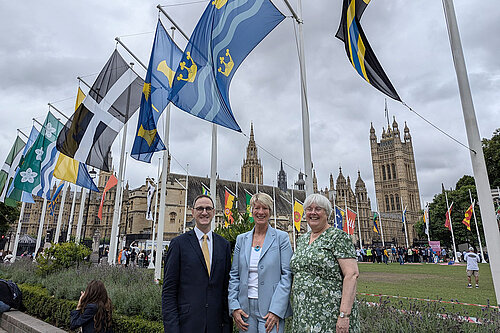 Pippa Heylings, Ian Sollom, Charlotte Cane underneath the Cambridgeshire flag outside parliament 23rd July 2024