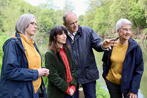 Jenny Wilkinson, Manuela Perteghella, Ed Davey and Susan Junes with trees and a river behind them