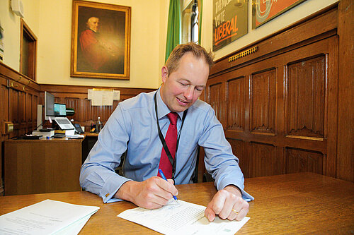 Richard Foord signing a letter